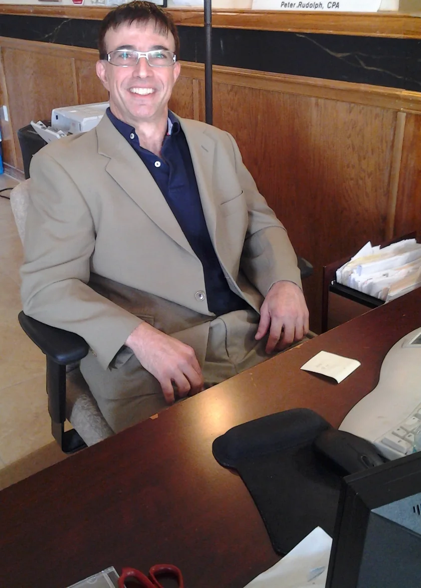 Peter Rudolph, CPA, seated at his office desk